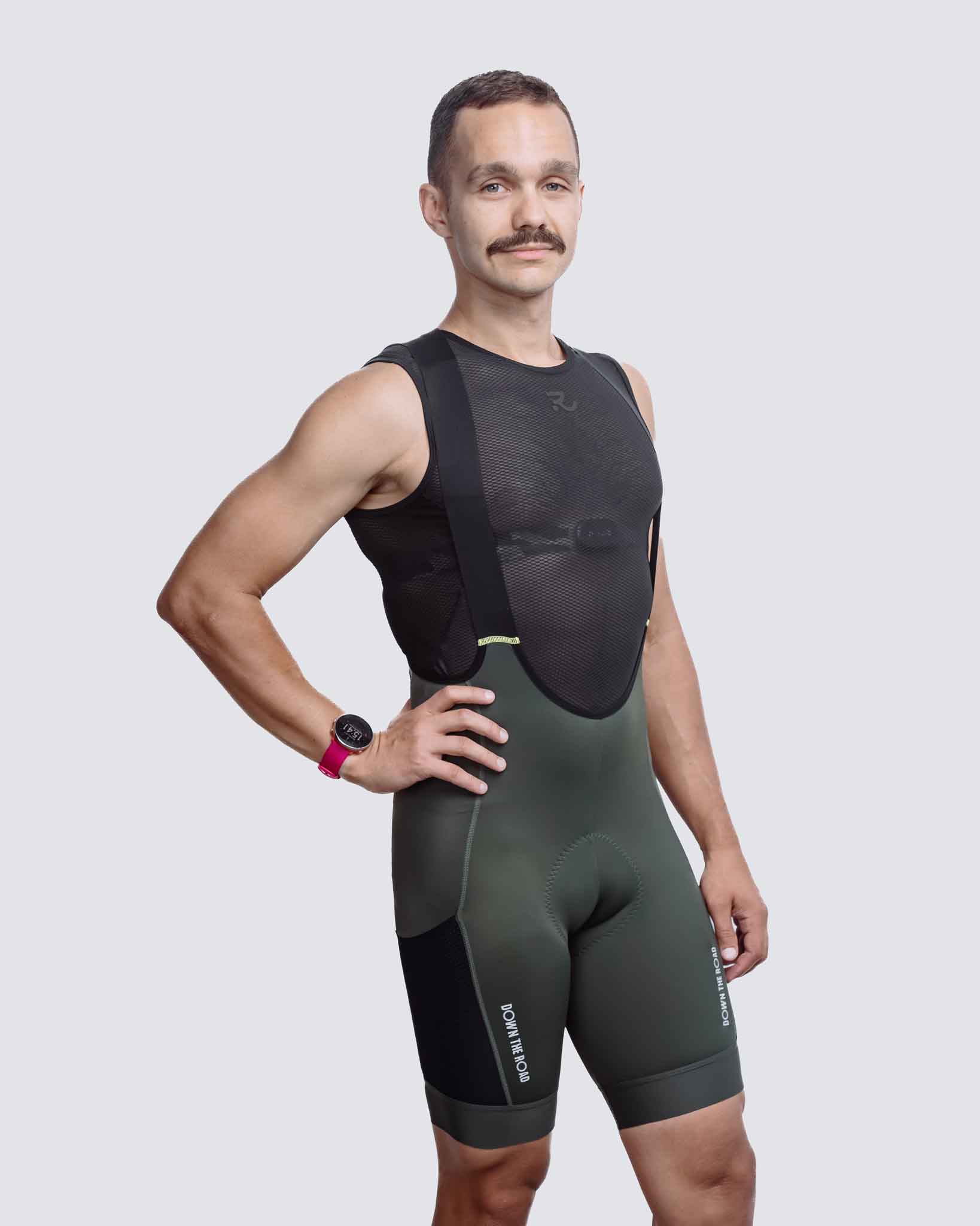 side view of man wearing green cargo bibs for men