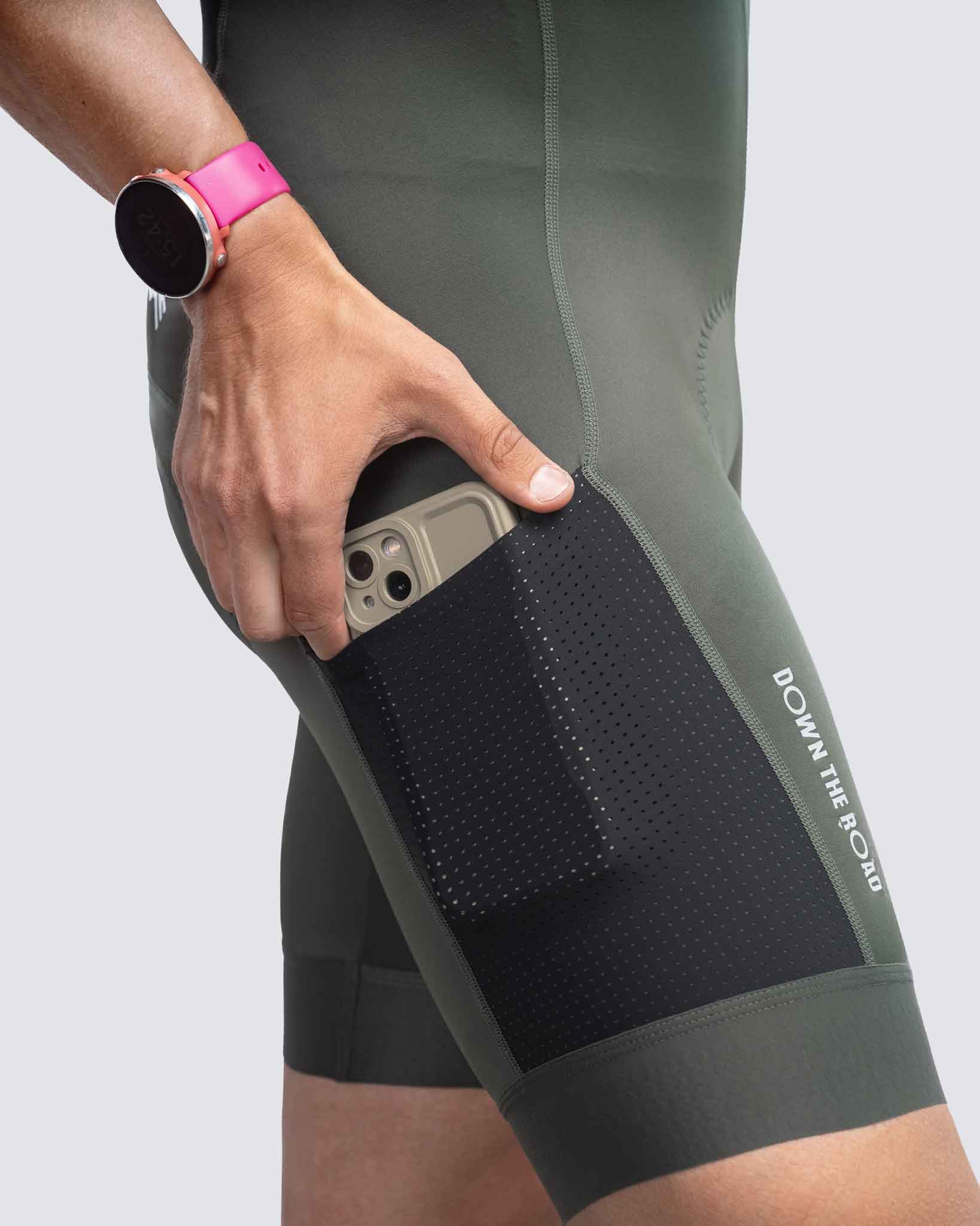 iphone in pocket of green cycling bibs for men