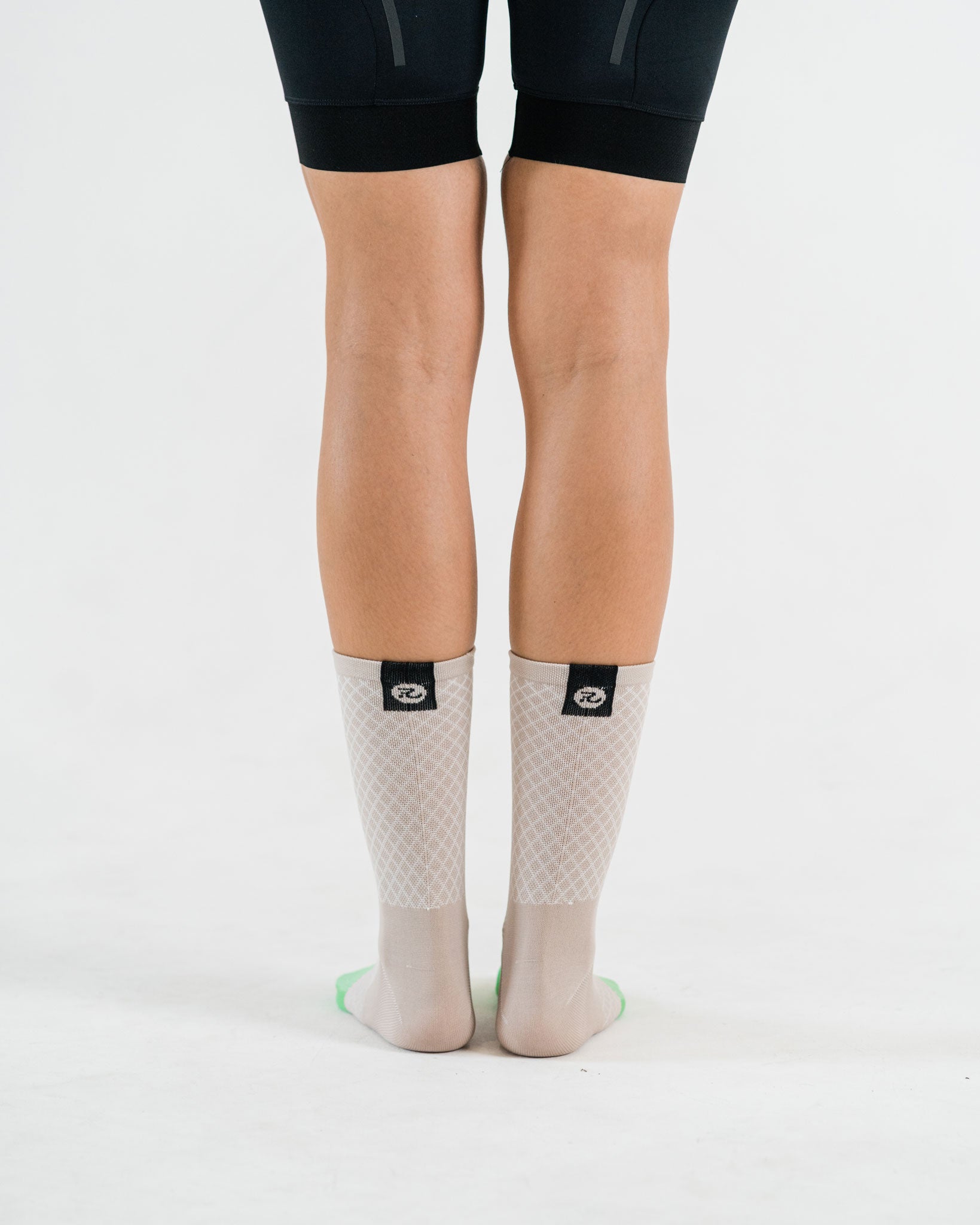 back of beige cycling socks with black down the road logo