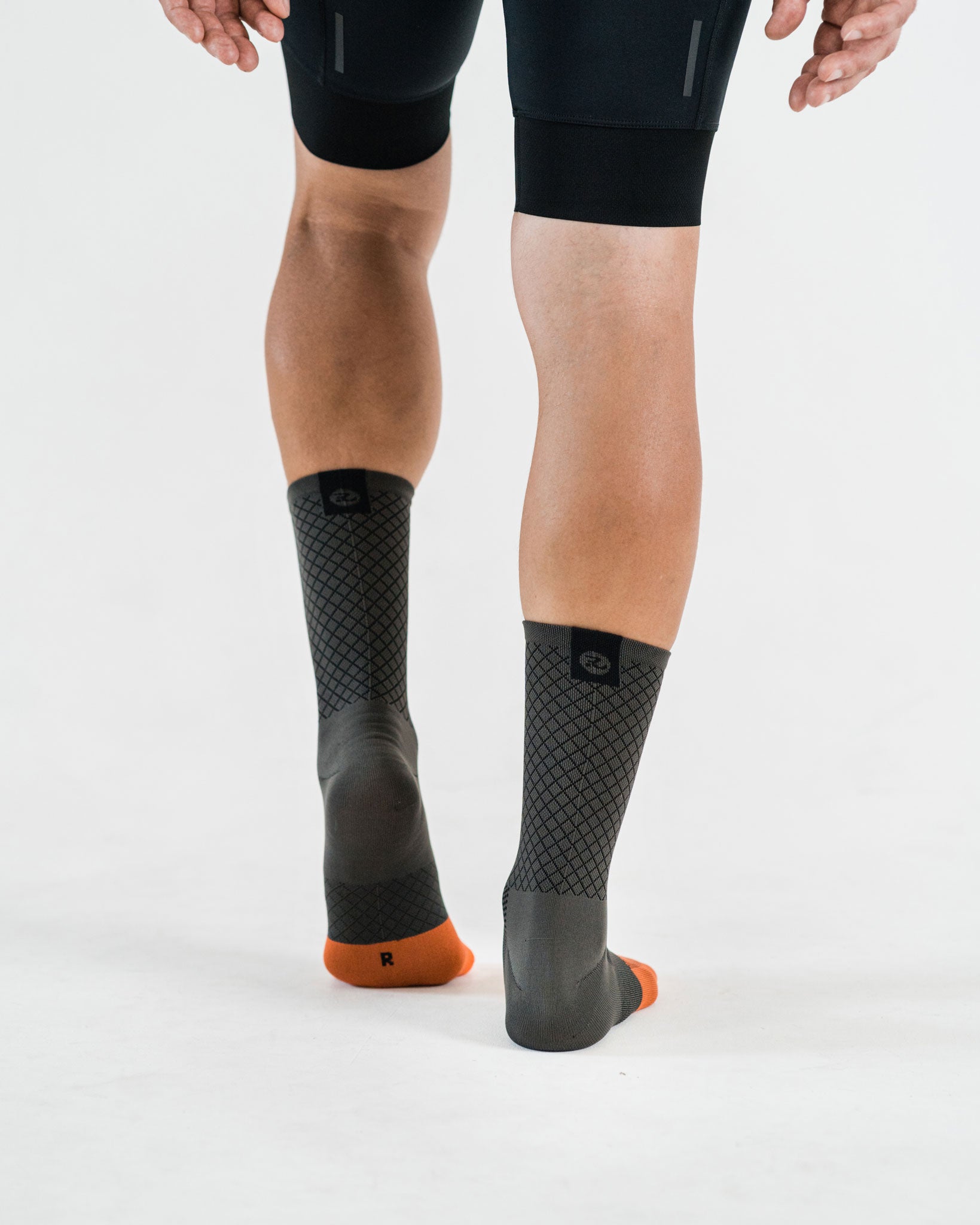 back view of grey socks with black and orange details